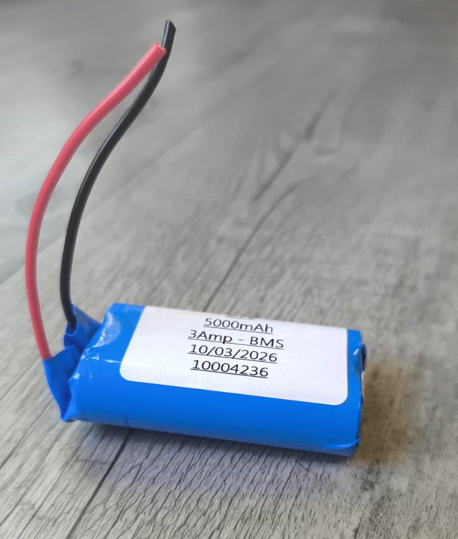 Battery with wires on a wooden surface